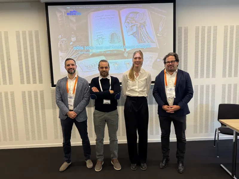 Roberto Mangano with three other participants in front of the MICCAI 2026 ODIN Workshop title slide